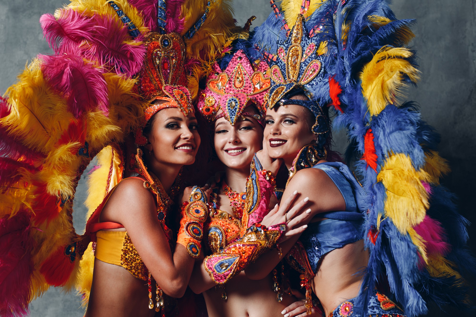 three woman brazilian samba carnival costume with colorful feathers plumage