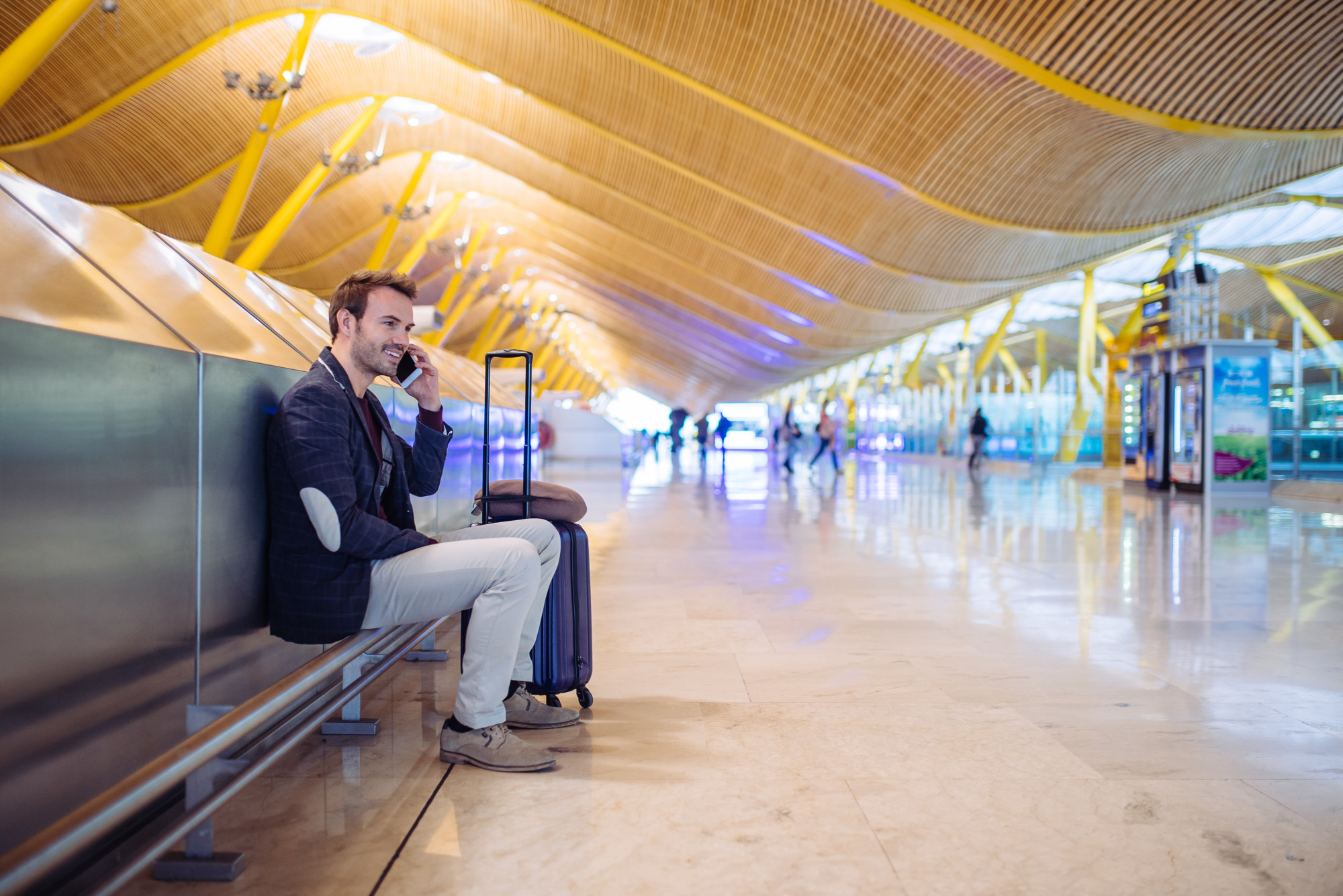 young-man-waiting-using-mobile-phone-airport