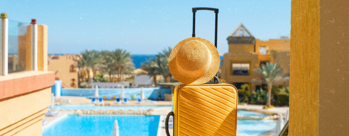 travel-summer-holidays-vacation-concept-yellow-suitcase-with-hat-background-hotel-pool-area-egypt