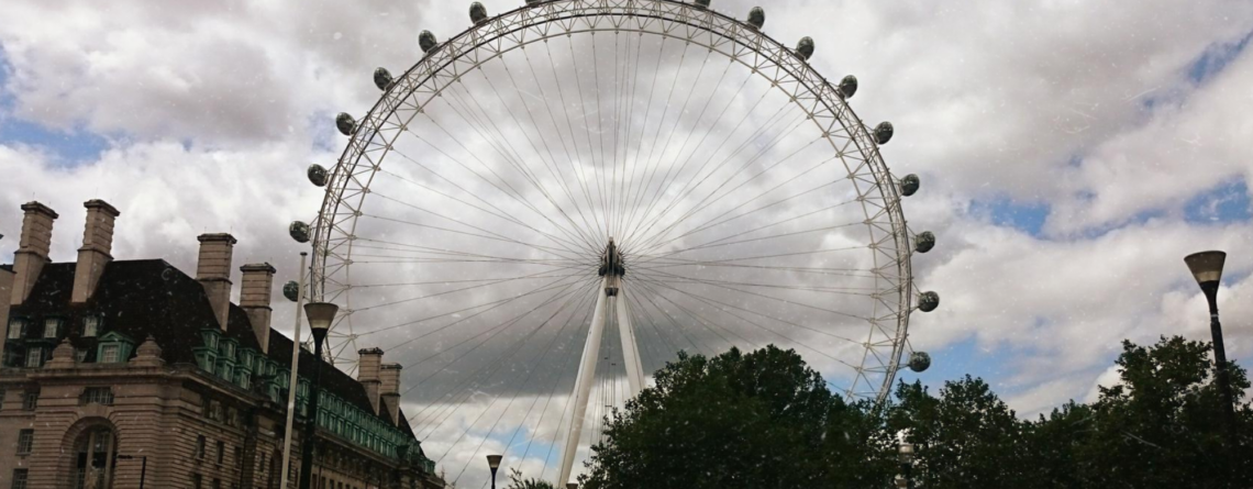 low-angle-view-london-eye-by-buildings-against-sky